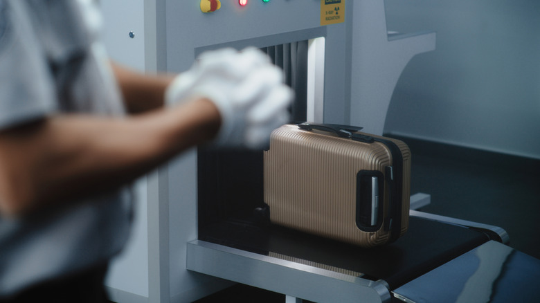 A suitcase passes through a scanner at airport security