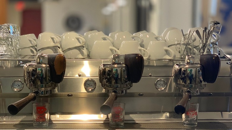 Espresso machine with coffee cups lined on top of it from Try Coffee