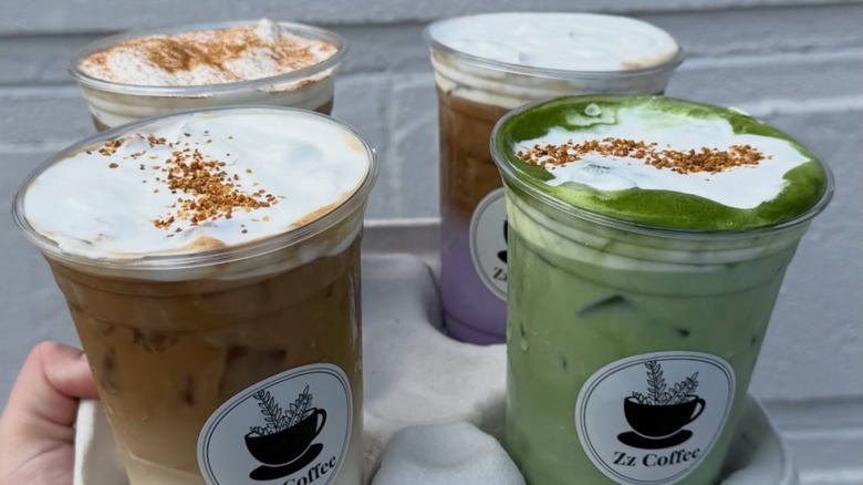 hand holding various coffee drinks in takeaway tray from Zz Coffee