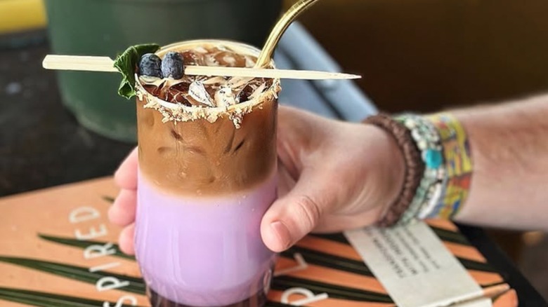 Colorful iced pink and brown drink with fresh berry garnish from Parlor Public House