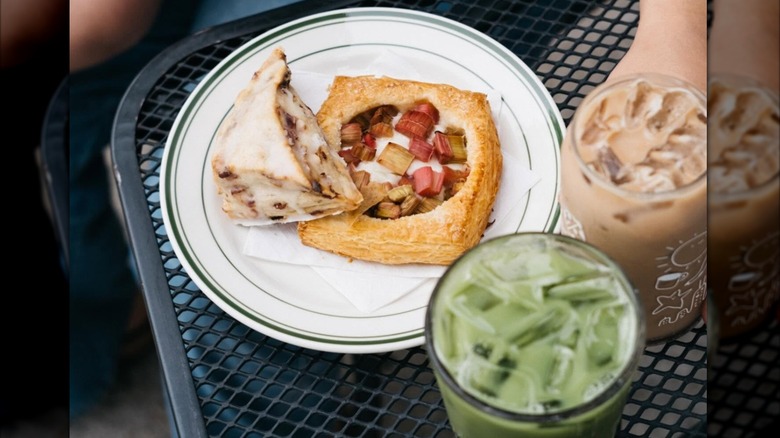 Two pastries on a plate beside an iced Matcha drink and iced coffee drink from Stovetop Coffee Roasters