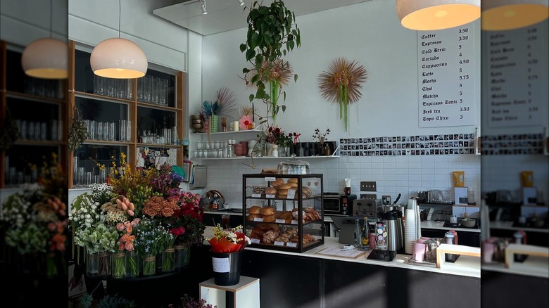 Interior of Pollen Coffee + Flower Shop with fresh flowers for sale on display, a coffee bar, fresh pastries and more