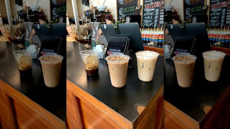 Three various iced coffee drinks in plastic to-go cups on counter at Mocha Joe's Cafe