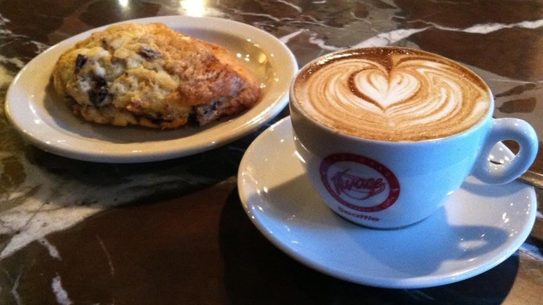 Cappuccino next to a big scone Espresso Vivace