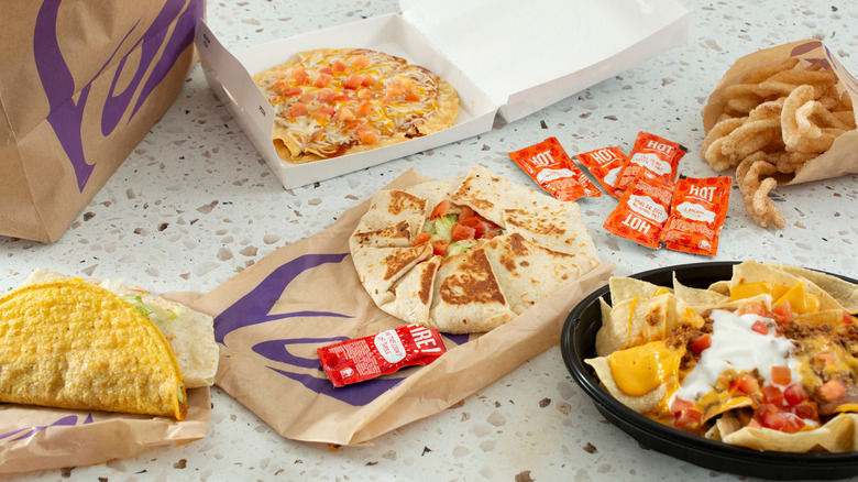 An array of Taco Bell products on a fast food dining surface.