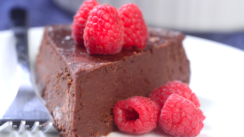 Close-up of a slice of no bake chocolate cake with raspberries