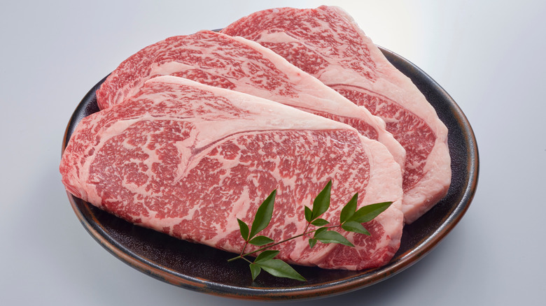 Slices of luxurious marbled Wagyu beef on a plate.