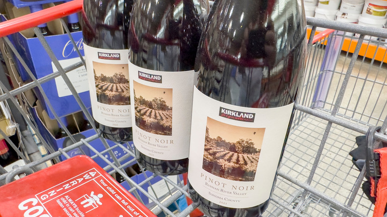 Three bottles of Kirkland pinot noir in a Costco shopping cart