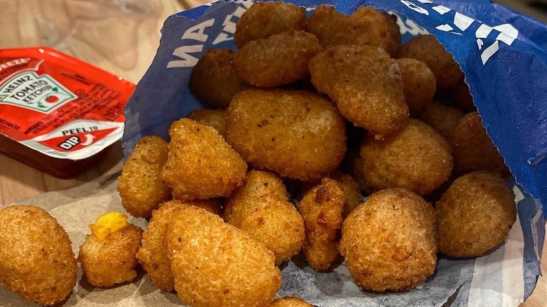Close-up of Culver's cheese curds and packet of Heinz ketchup