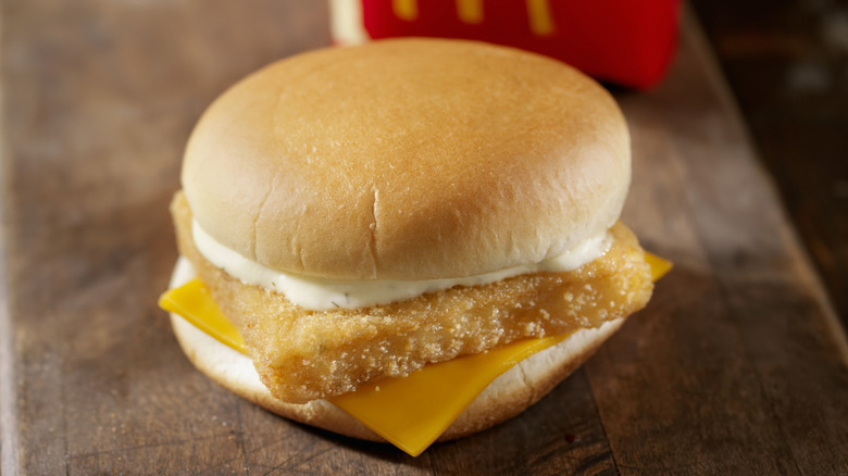 A Filet-O-Fish sandwich rests on a wooden surface