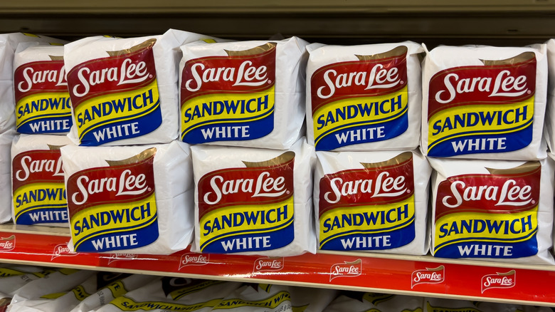 A shelf stocked with Sara Lee white bread