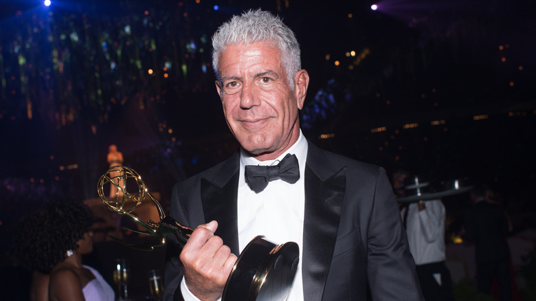 Anthony Bourdain holding an Emmy award