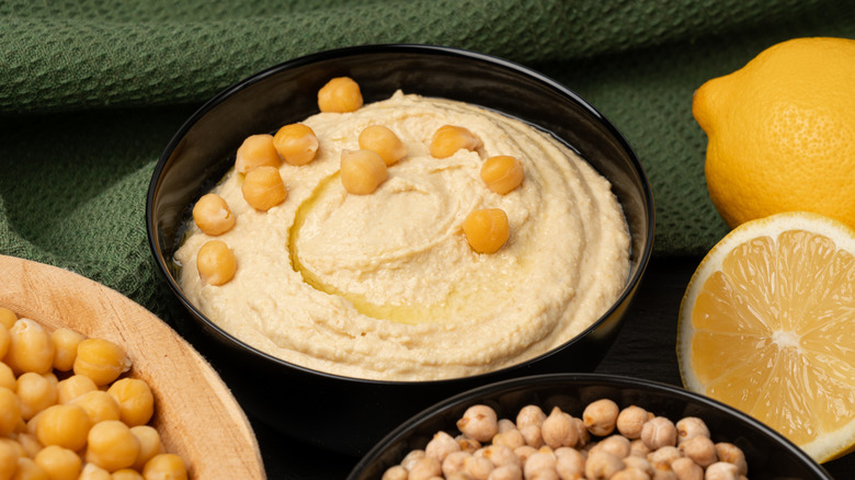 Hummus in a bowl with fresh lemons