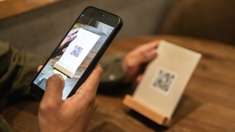 Hand holding phone and scanning QR code restaurant menu