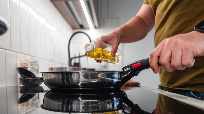 A man pouring oil into a pan