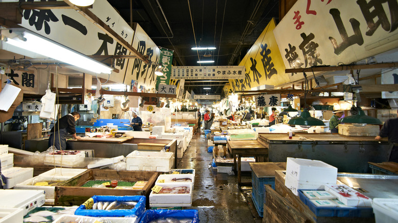 A seafood market in Japan with workers cutting and preparing fish