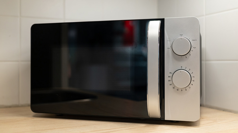 A microwave oven with a black door, sitting on a kitchen counter