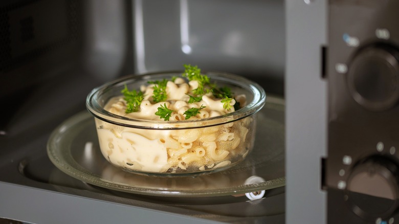 Mac and cheese in glass bowl in microwave