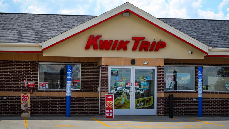 Front of a Kwik Trip gas station convenience store, showing the logo in red across the cream-colored A-frame facade