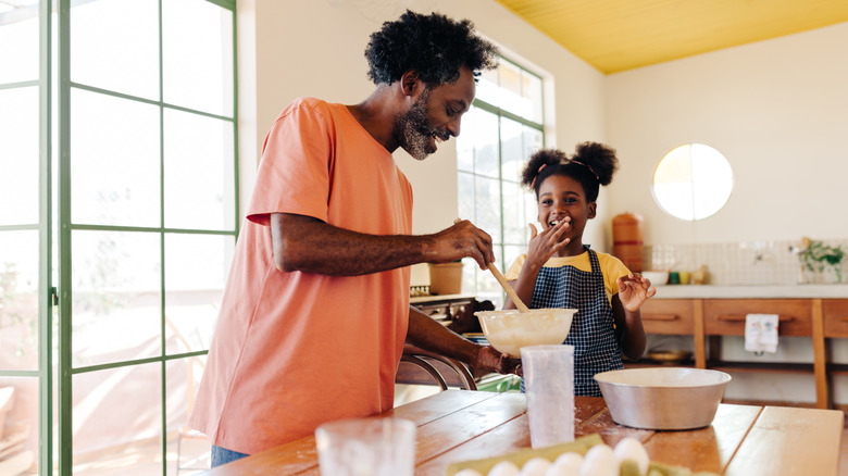 Father and daughter baking a cake