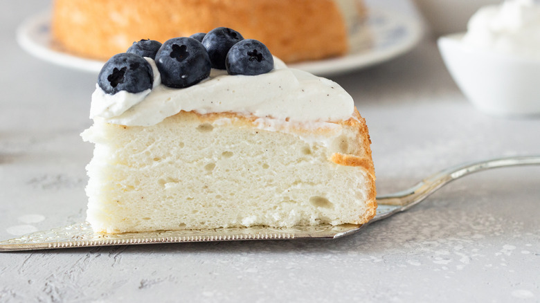 Slice of frosted angel food cake with blueberries on top