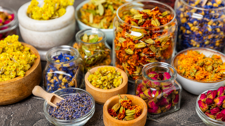 An assortment of loose leaf teas in jars, bowls, and containers