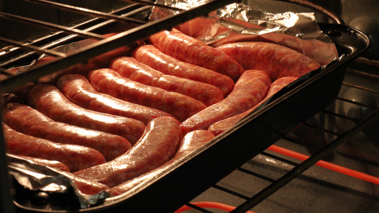 Sausages being cooked in a pan in an oven