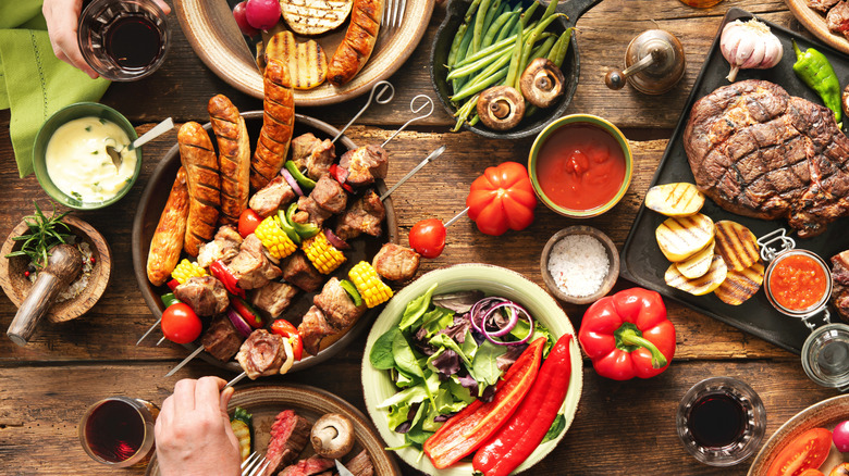 Meal spread including sausages and many different sides