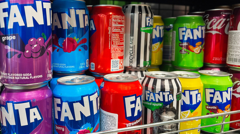 Cans of various carbonated drinks on a store shelf