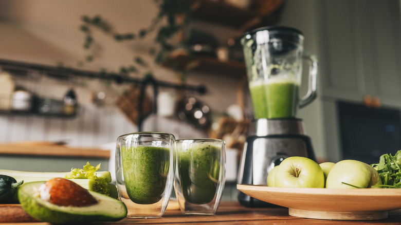 Blender and glasses of green smoothie