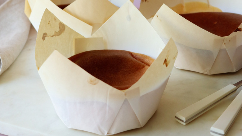 The muffins are displayed with parchment paper liners on a white table.