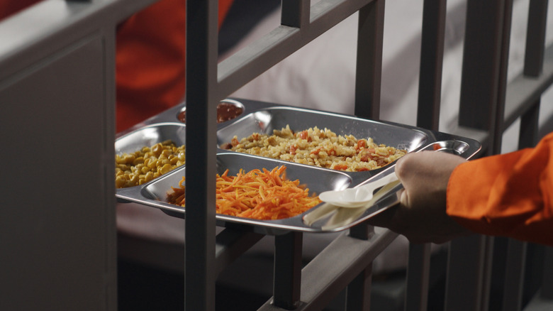 Tray of food being passed through prison bars