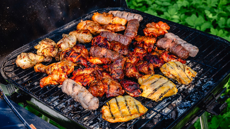A variety of meat being grilled outside