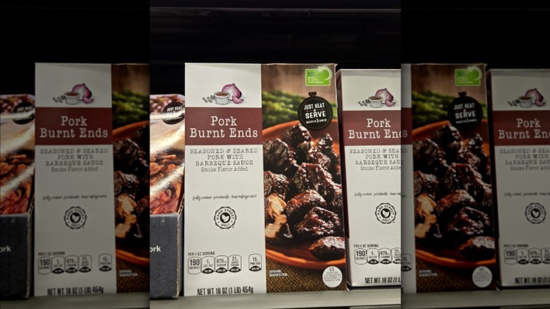 Close up of packages of Aldi Park Street Deli Pork Burnt Ends lined up in an Aldi refrigerated case.