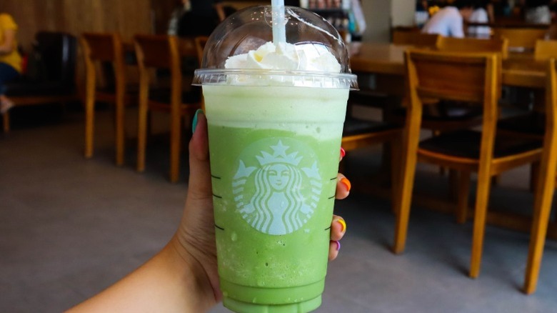 Hand holding a green Venti Starbucks Frappuccino.