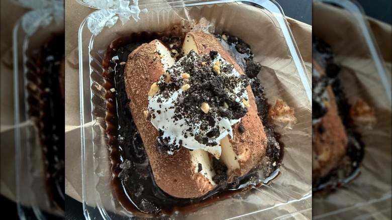 An Idaho ice cream potato, topped with whipped cream, cookie crumbles, and nuts.