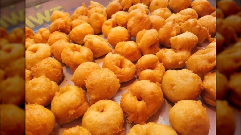 A tray full of Stella's Zeppole's golden brown, freshly fried zeppole.