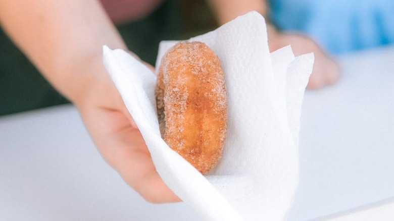 A fresh, sugar-coated Ben-Ellen doughnut served in a white paper napkin.