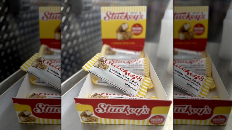 Close-up of several wrapped Stuckey's Pecan Rolls for sale on a shelf, with a blurred background