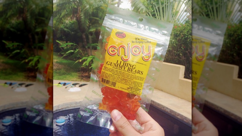 Hand holding a bag of Li Hing Mui Gummy Bears candy