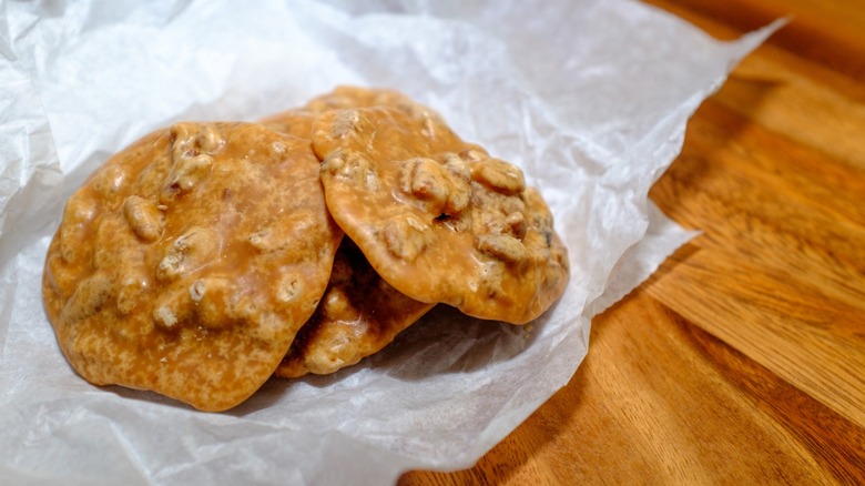 Pecan pralines on parchment paper on wooden table