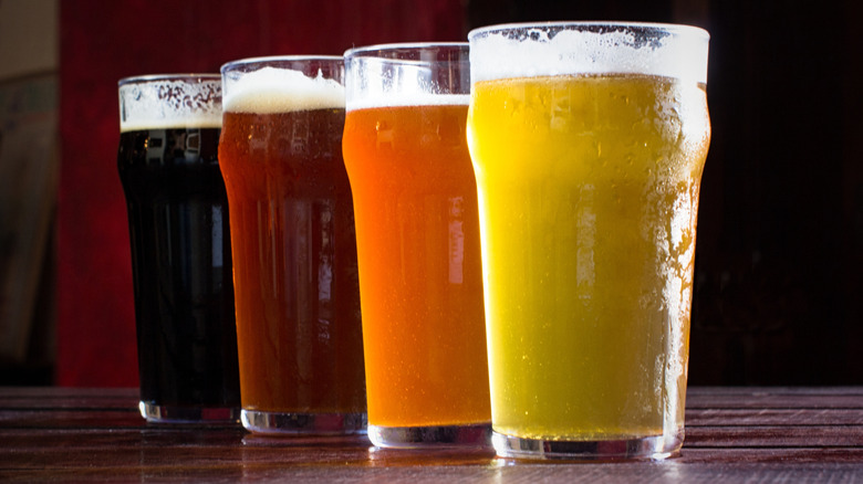 A row of pint glasses with different styles of beer
