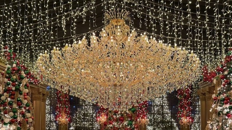 Interior room of Cava showing a huge, elaborate chandelier surrounded by string lights hanging from the ceiling and Christmas decorations around the room