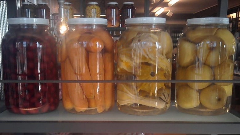 A display in the interior in Founding Fathters of four large jars on a shelf, containing (l-r) radishes, carrots, winged gourds, and onions