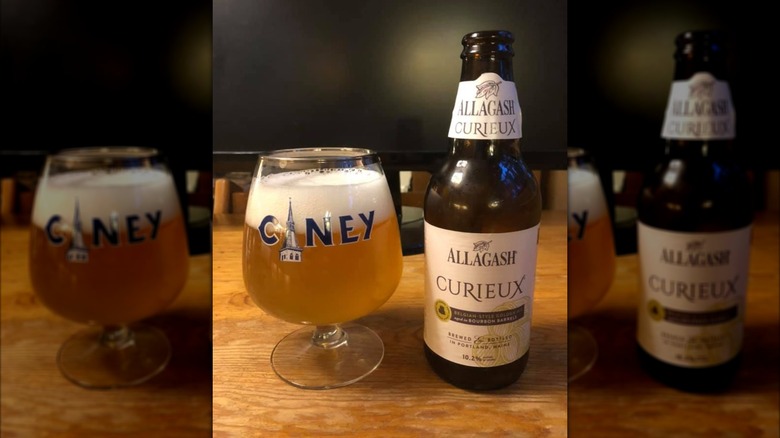 A pilsner glass of Allagash Curieux with bottle