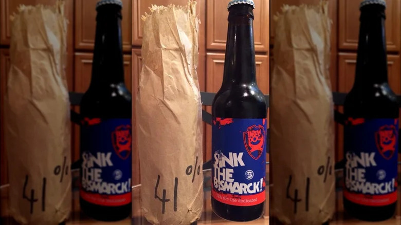 A bottle of Sink the Bismarck! next to a bottle in a paper bag