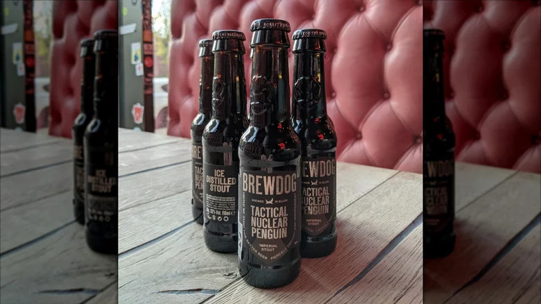 Four bottles of Tactical Nuclear Penguin on a wood table with a red background
