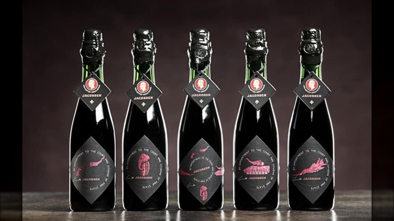 Five bottles of Carlberg's Jacobsen Vintage No. 1 on a table, each with a different label.