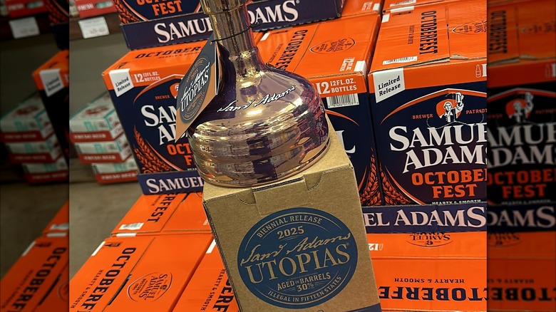 A cask-shaped bottle of Sam Adams Utopias on top of cases of October Fest