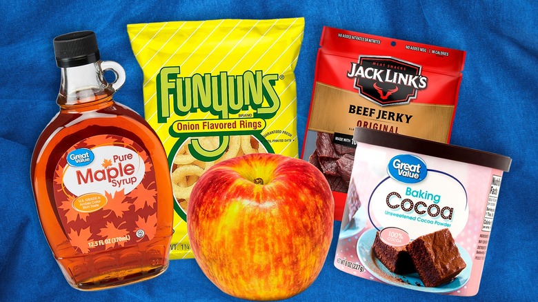 Great Value Maple Syrup, Funyuns, Jack Link's Jerky, baking cocoa, and an apple on blue backdrop